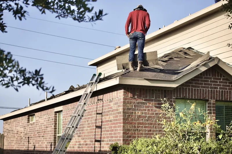 Professional roofer working on a residential roof in Ludlow